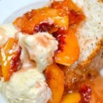 Toasted bread topped with vanilla ice cream and glossy grilled peach sauce on a decorative plate