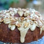 Apple Cream Cheese Bundt Cake with cream cheese glaze and sliced almonds on a blue plate, overhead view