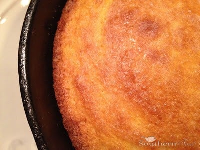 Golden-brown Southern Cornbread in Cast Iron skillet with crispy edges, resting on white surface