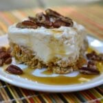 Butter pecan Ice Cream Cereal Squares on white plate with caramel drizzle and pecan garnish on striped placemat