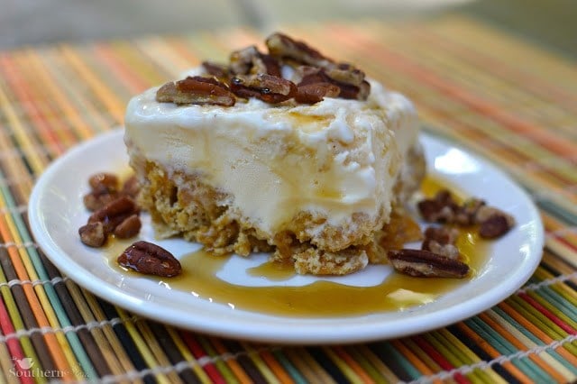 Butter pecan Ice Cream Cereal Squares on white plate with caramel drizzle and pecan garnish on striped placemat
