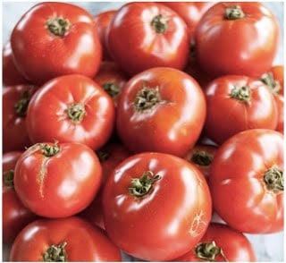 Fresh ripe red tomatoes clustered together overhead view for tomato shot in Southern cooking