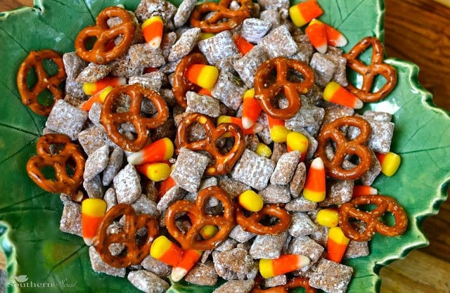 Candy Corn Snack Mix with pretzels, cereal, and candy corn on green leaf-shaped plate, overhead view