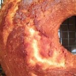 Brown Sugar & Cream Cheese Pound Cake cooling on wire rack, showing dense crumb with cinnamon swirl and powdered sugar dusting