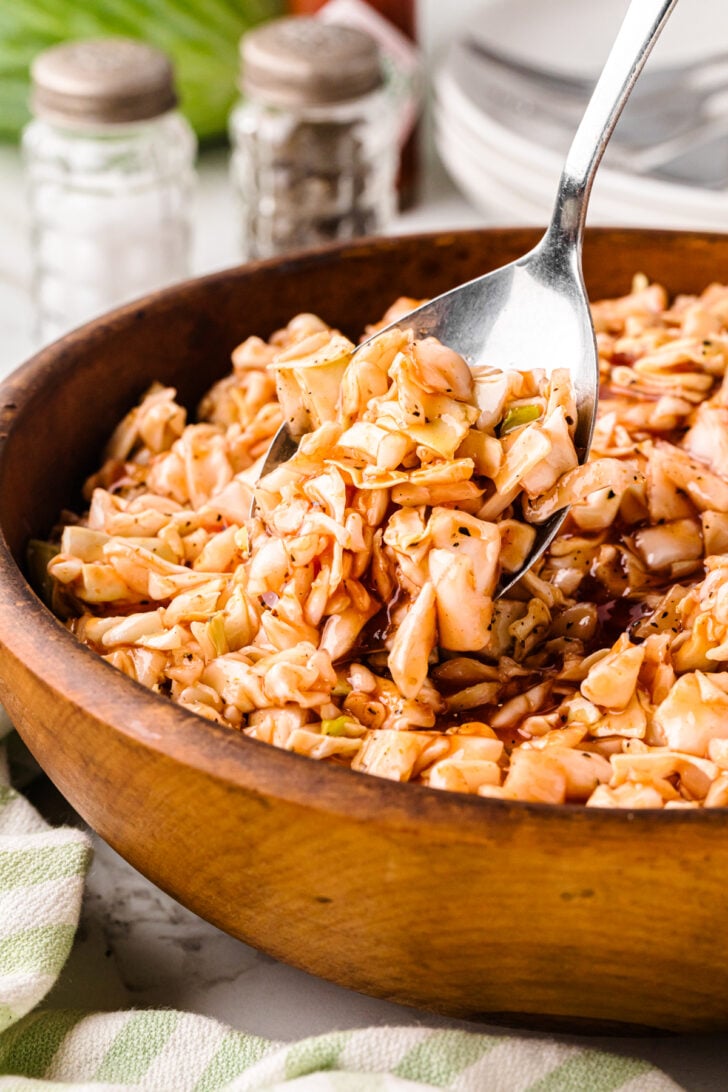 Carolina BBQ red slaw served in a wooden bowl with a silver spoon.