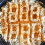 Waffle Iron Hash Browns cooked golden brown in cast iron skillet, overhead view with crispy edges and white interior visible