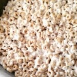 Honey Nut Marshmallow Treats cereal squares stacked together in a white bowl, showing the golden and white marshmallow pieces throughout