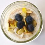 Blueberry Almond Overnight Oats in a glass jar topped with fresh blueberries and sliced almonds, viewed from above