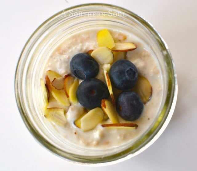 Blueberry Almond Overnight Oats in a glass jar topped with fresh blueberries and sliced almonds, viewed from above