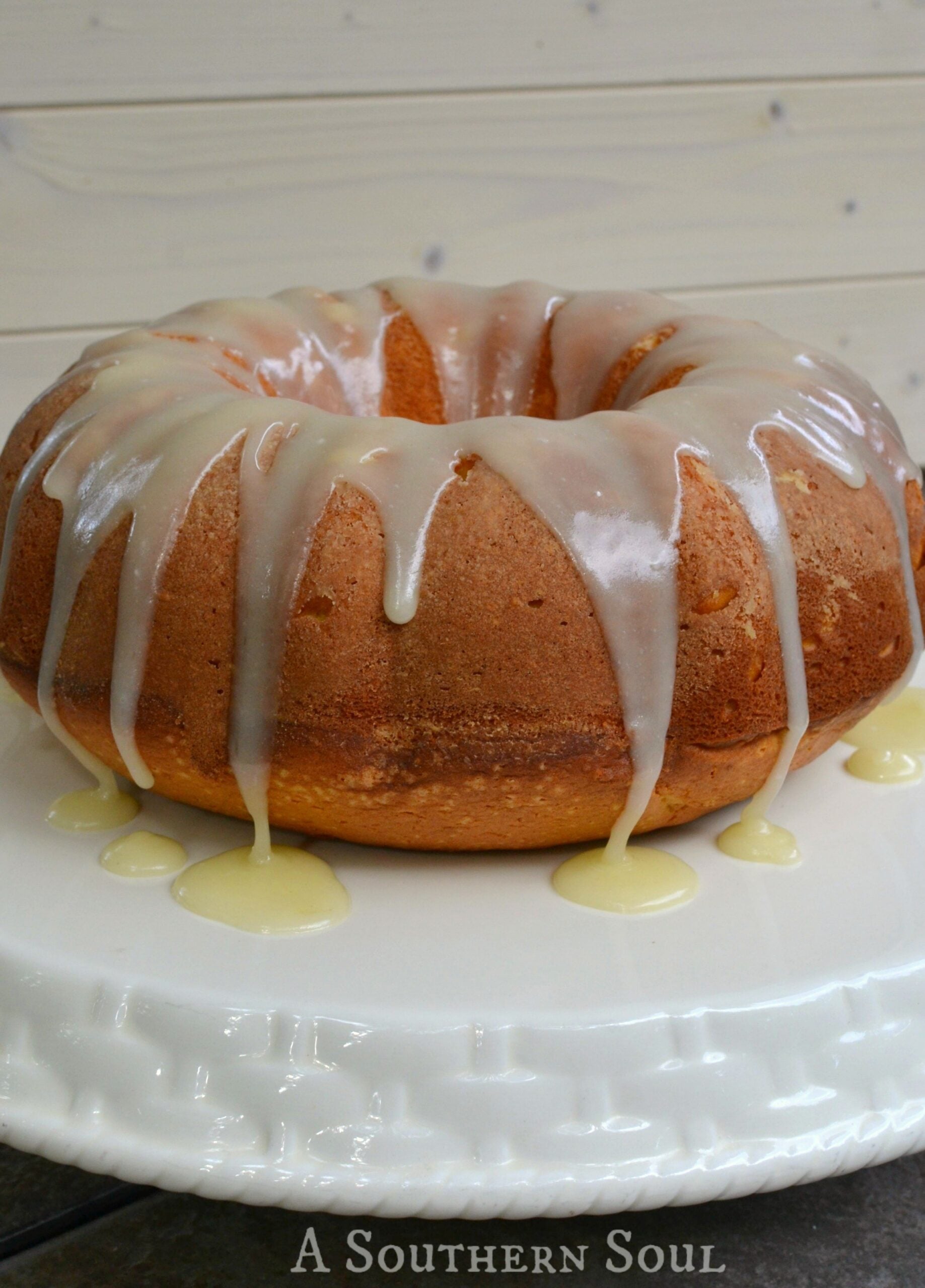 Glazed bundt cake with white icing drizzle and yellow sauce pooling around base on white plate, Blue Cheese Coleslaw recipe