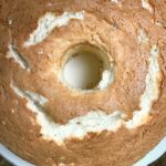 Overhead view of a chocolate angel food cake with white frosting swirls on a white plate from A Southern Soul blog