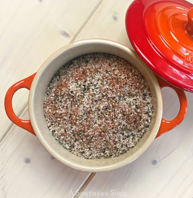 Homemade House Seasoning Recipe in red Dutch oven with orange handles on white wood surface, overhead view