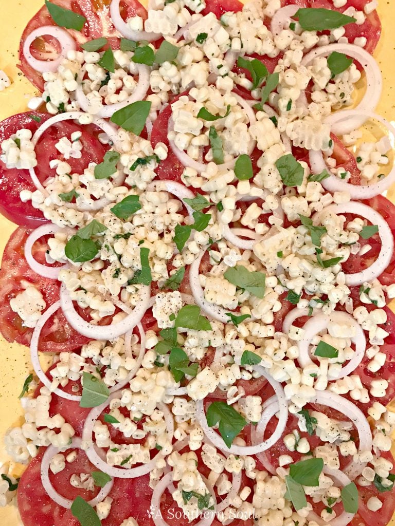 tomatoes, vidalia onion, corn, basil salad for summer on platter