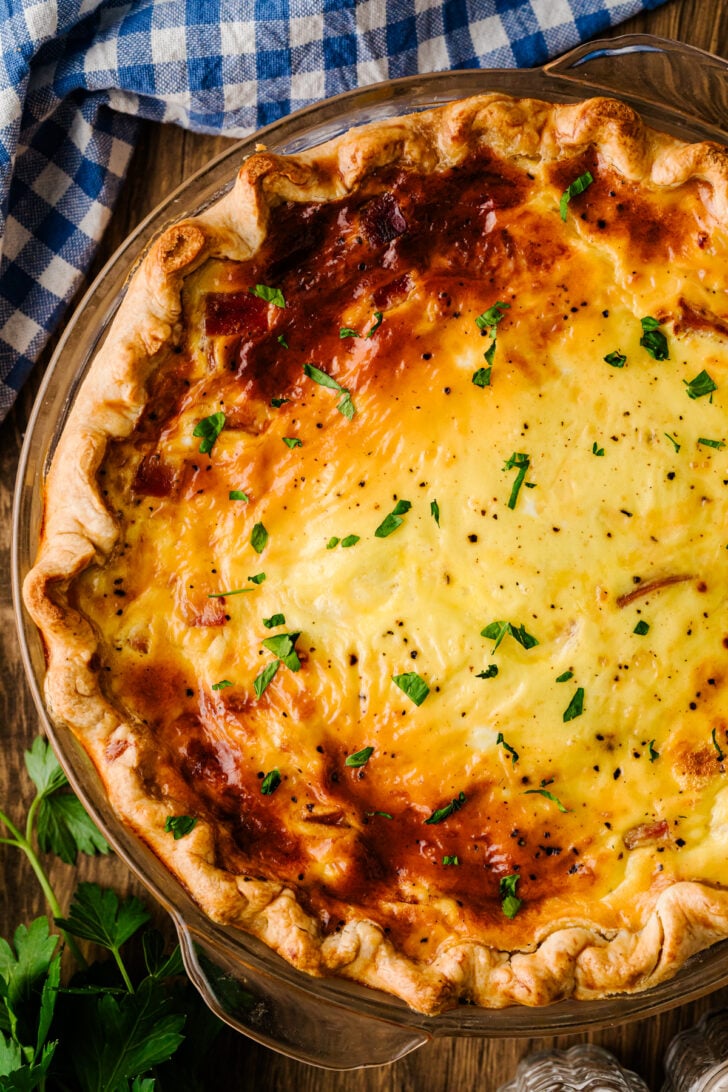 Ham and cheese quiche baked in a deep-dish pie crust, golden on top and fresh from the oven.