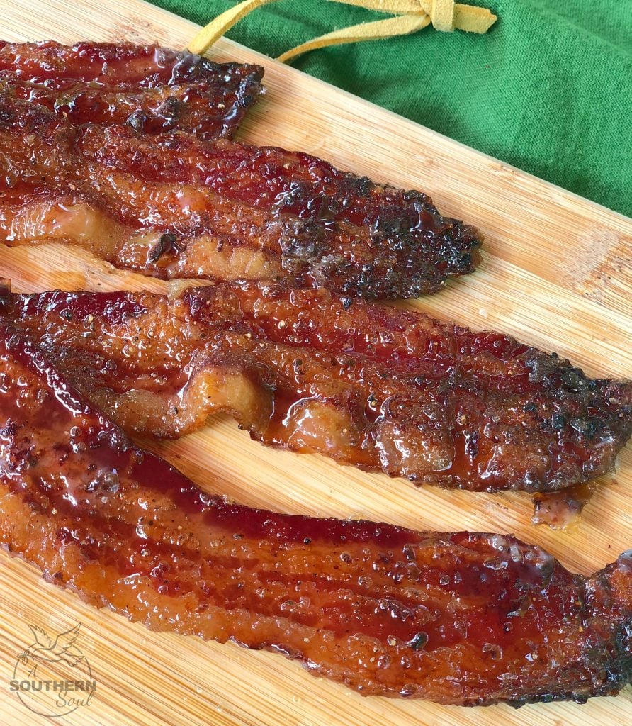 The salty, sweet crunch of candied bacon with a peppery kick will have you licking your lips with every bite and it's served on a woodend cutting board.
