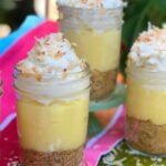 No Bake Coconut Cream Pie In Jars with graham cracker crust, creamy custard filling, whipped cream, and toasted coconut flakes in glass jars