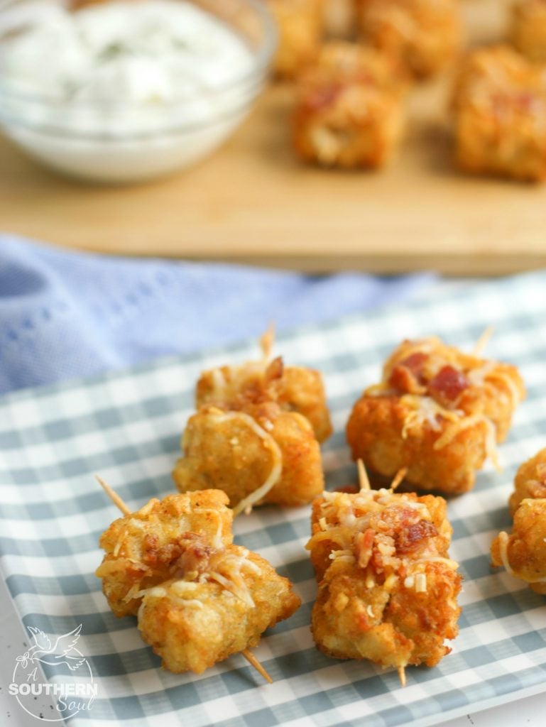Tater Tots made into loaded little appetizer bites are a great appetizer or snack. Topped with cheese & bacon then dipped into creamy sour cream, they become a savory treat everyone will love.