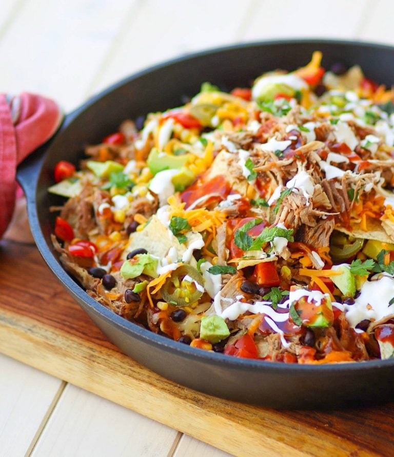Pulled Pork cooked in the Instant Pot is tender and juice. It's then turned into nachos loaded with cheese, beans, corn, peppers, avocado, BBQ sauce and sour cream for a dish that is out of this world!