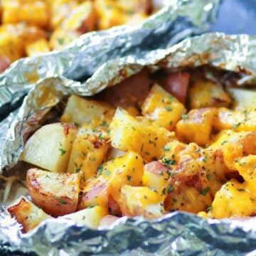Red potatoes flavored with ranch seasoning then cooked on the grill in foil packets are loaded with cheese for a side dish that is perfect for any cookout or BBQ!