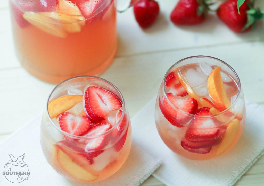 Rose sangria flavored with peach schnapps, peach juice with fresh fruit is a cool drink that's excellent for summertime!,