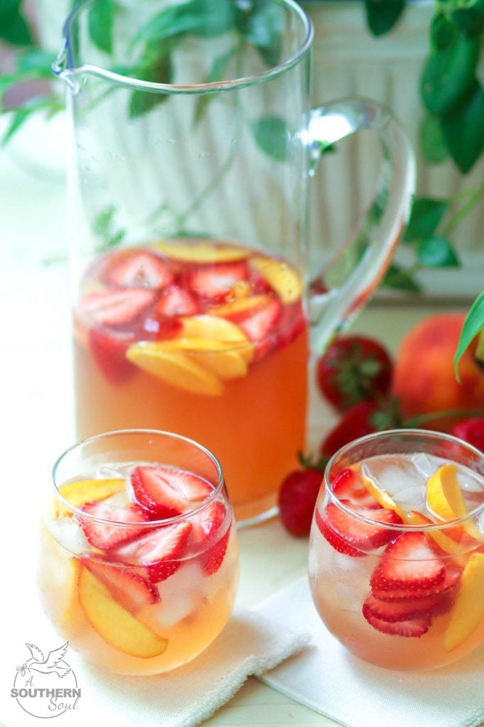 Rose sangria flavored with peach schnapps, peach juice with fresh fruit is a cool drink that's excellent for summertime!,