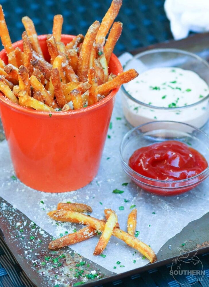 Store bought shoe string potatoes are fried to perfection with very little oil in the air fryer. They are tossed in garlic butter then sprinkled with salt, Parmesan cheese and parsley for a treat that is crazy good!