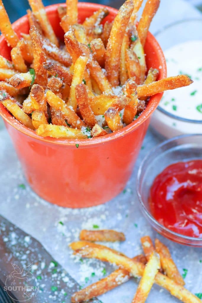 Store bought shoe string potatoes are fried to perfection with very little oil in the air fryer. They are tossed in garlic butter then sprinkled with salt, Parmesan cheese and parsley for a treat that is crazy good!