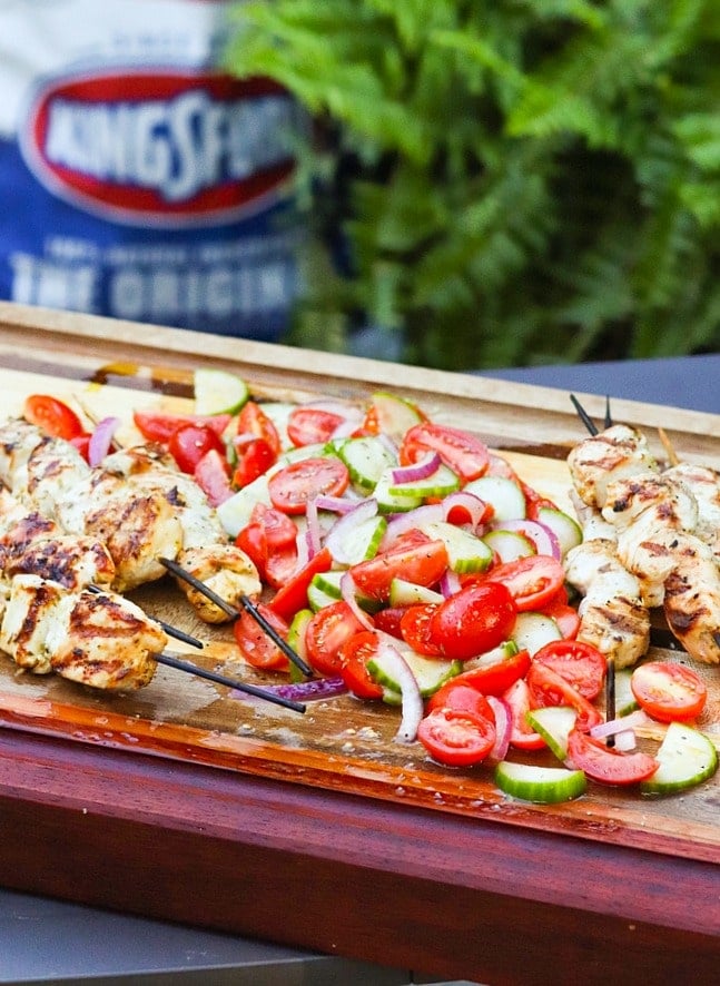 Grilled Chicken Souvlaki Skewers are juicy and tender. Make with lemon juice, oregano, garlic, salt and pepper. Add in a chopped salad with tomatoes, onions and cucumbers and you've got a meal your friends and family will love!