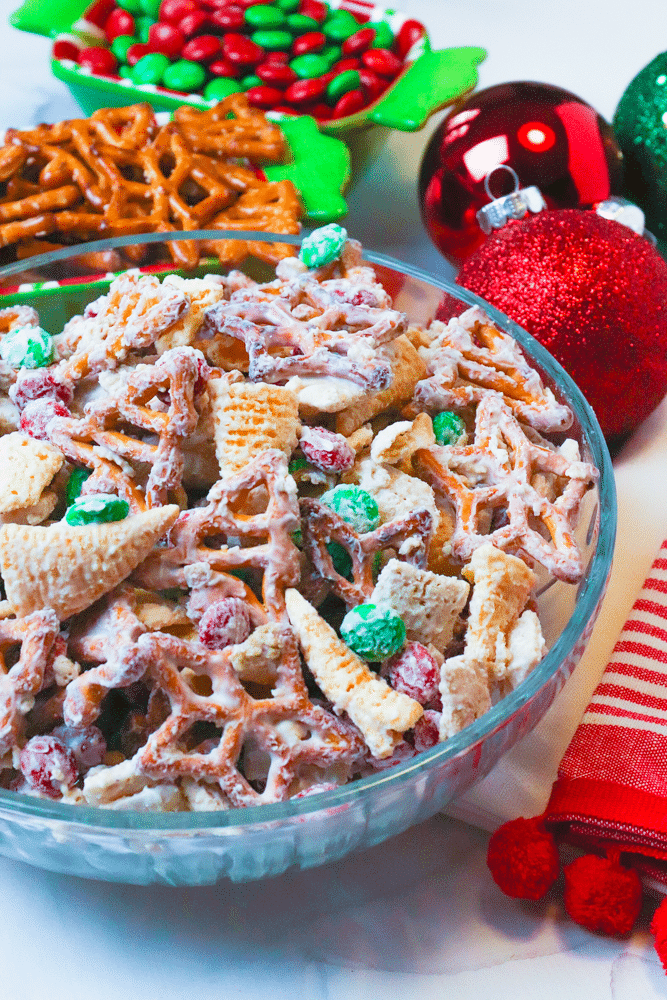 Christmas Snack Mix is a festive blend of rice cereal, pretzels, corn snacks and M&M all coated is a sweet vanilla bark. This easy to make treat is sure to make Christmas extra sweet.