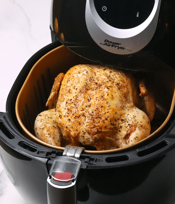 Seasoned Air Fryer Whole Chicken with crispy golden skin in black Power Air Fryer basket, overhead view