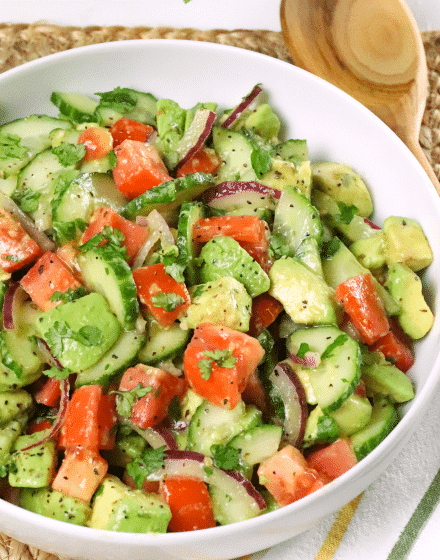 Cucumber Tomato Avocado Salad is full of fresh, bright flavor. Made with sliced cucumbers, tomatoes and avocados drizzled with a simple dressing of olive oil, vinegar mixed with garlic is great to serve any time of the year.