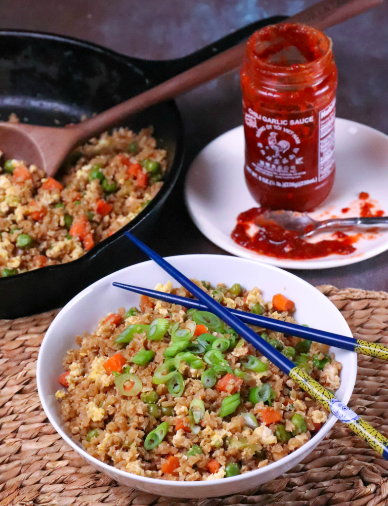 Cauliflower Fried Rice is a low carb version of your favorite Chinese take out dish. Made with cauliflower, eggs, carrots, and peas, it's seasoned with soy sauce and garlic all ready in less than 20 minutes!