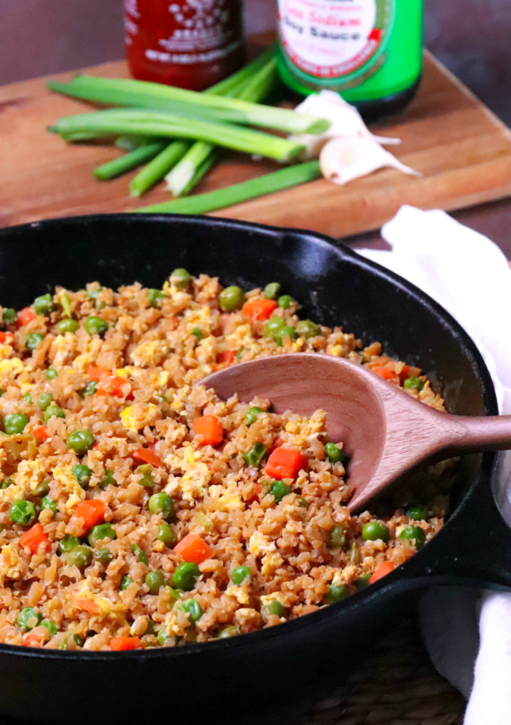 Cauliflower Fried Rice is a low carb version of your favorite Chinese take out dish. Made with cauliflower, eggs, carrots, and peas, it's seasoned with soy sauce and garlic all ready in less than 20 minutes!