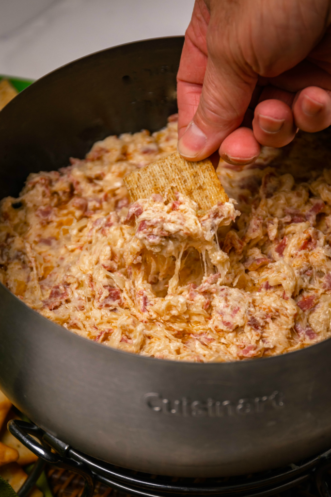 Crock Pot Reuben Dip is so easy to make with just a few ingredients. Make with corned beef, sauerkraut, thousand island dressing and swiss cheese just like the famous, classic sandwich!