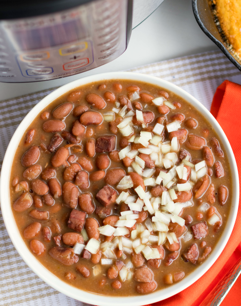 Instant Pot Pinto Beans are so easy to make! Seasoned with ham, onion and garlic then cooked in vegetable stock, this no-soak recipe is great as a main or side dish.