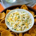 Mexican Corn Dip made with white and yellow corn, mayonnaise, sour cream, cojita cheese, canned green chilies, chicli powder, garlic, salt and cilanto. A yummy, easy to make appetizer servd with corn chips or tortillas.