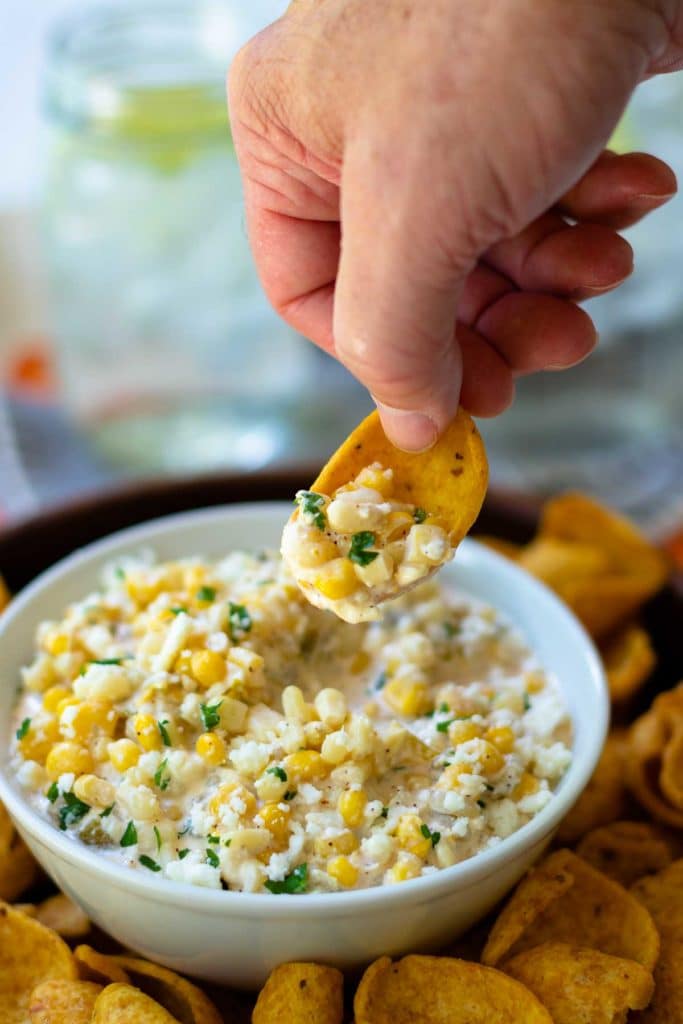 Mexican Corn Dip made with white and yellow corn, mayonnaise, sour cream, cojita cheese, canned green chilies, chicli powder, garlic, salt and cilanto. A yummy, easy to make appetizer servd with corn chips or tortillas.