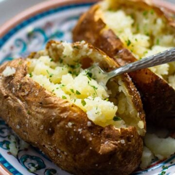 Baked Potatoes made in the Air Fryer are tender and fully on the outside with a crispy skin that makes them irresistible. Easy to make, just add your favorite toppings like butter, chives, sour cream, salt and pepper.