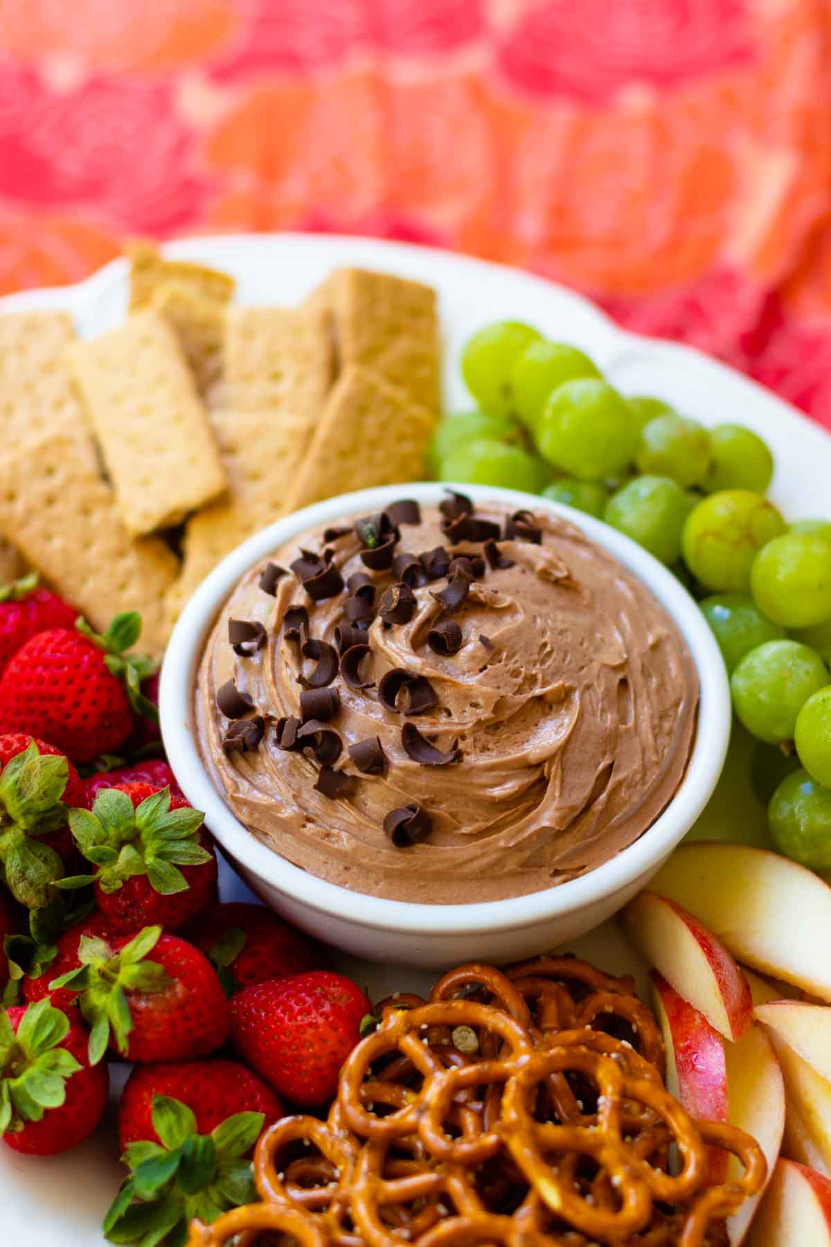 Chocolate Dip in bowl on fruit platter with cookies and pretzels.