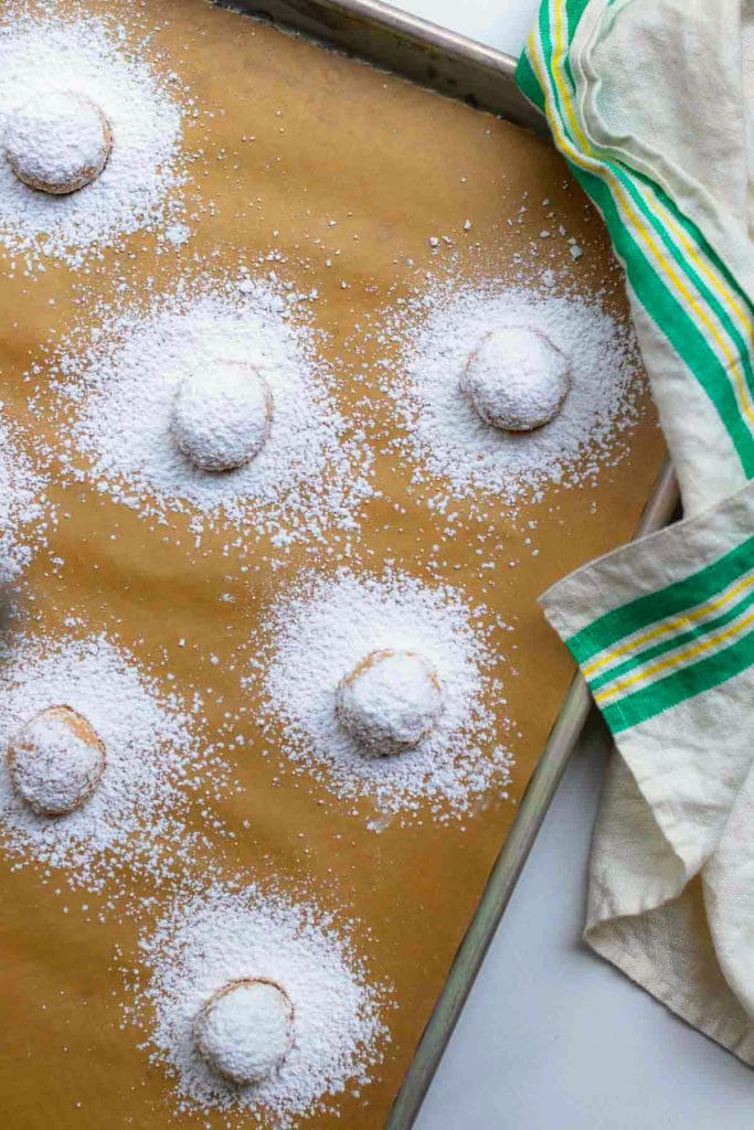 Pumpkin Crinkle Cookies with powdered sugar on parchment uncooked.