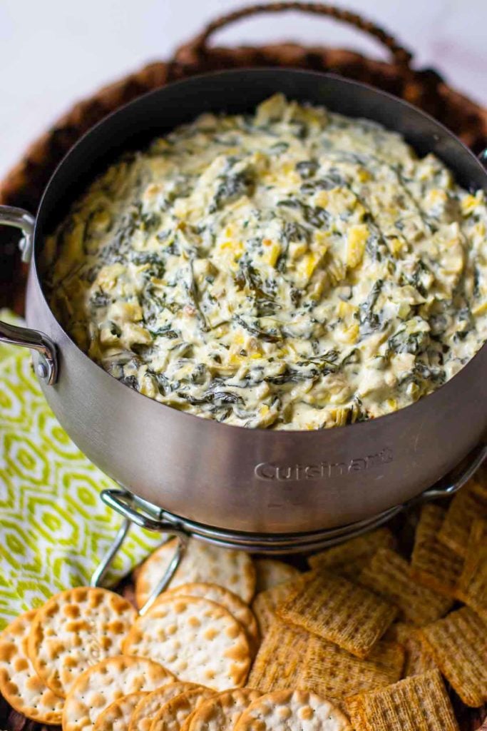 Spinach Artichoke Dip in small crock pot with crackers.