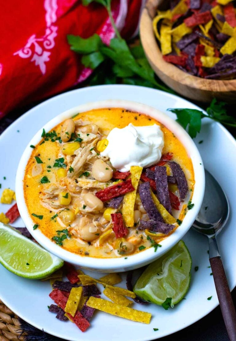 Easy to make White Chicken Chili in a bowl topped with cool sour cream and tortilla chips is totally delcious!