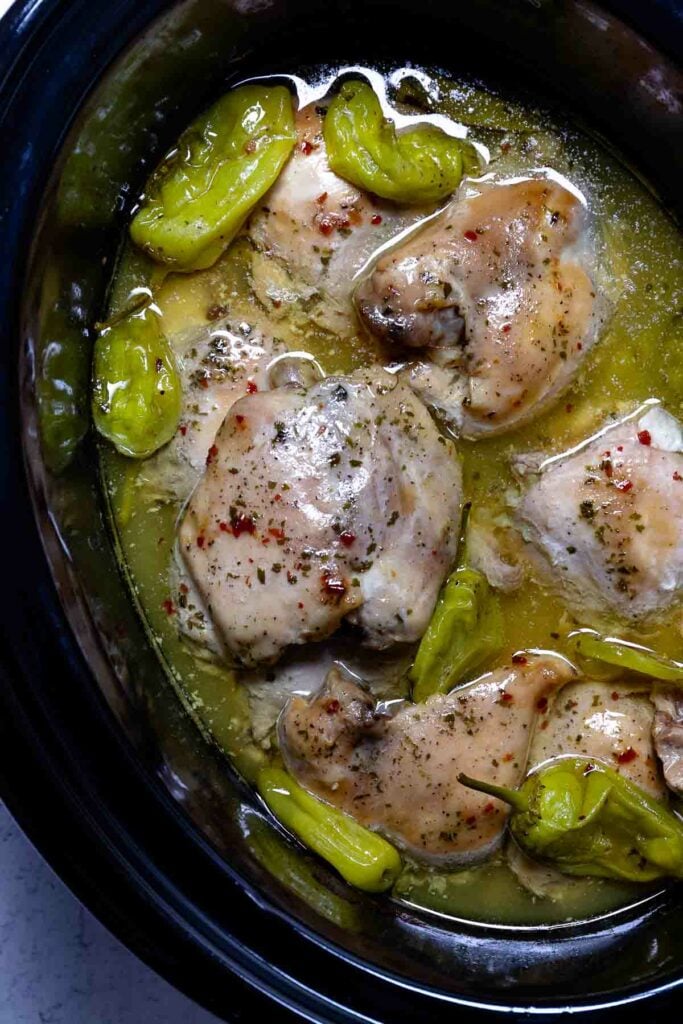 Crock Pot Mississippi Chicken with pepper and ranch seasoning in crock pot.
