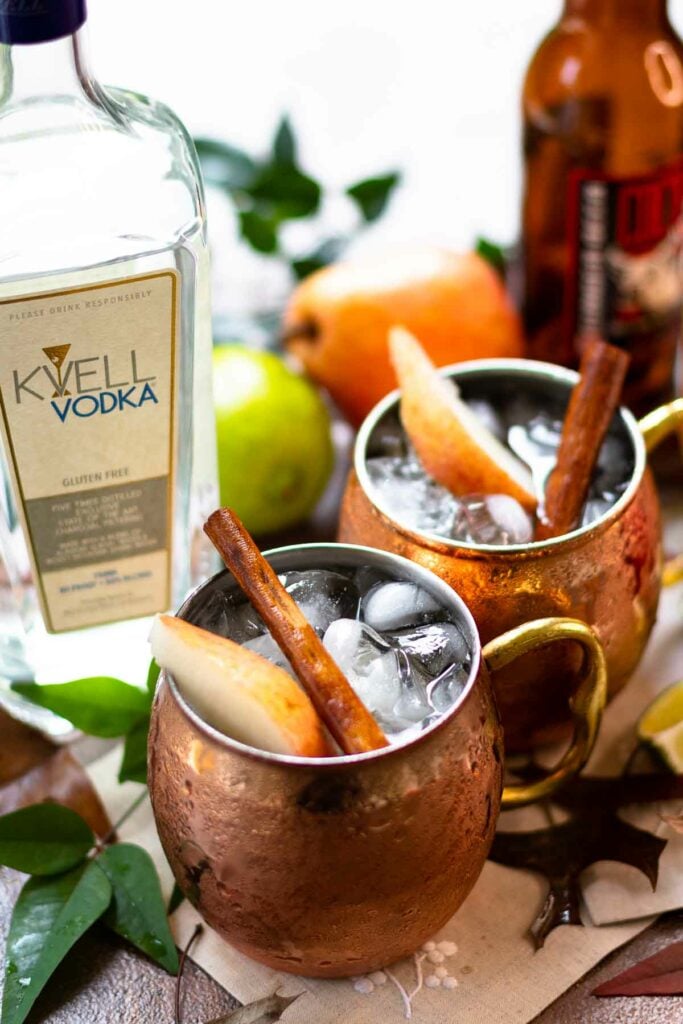 Kvell vodka and copper mugs filled with moscow mules.