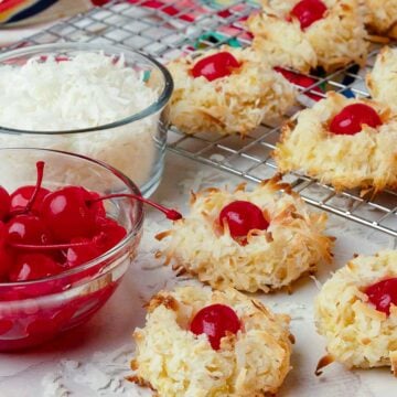 Ambrosia Cookies with red cherries and white coconut on a rack cooking.