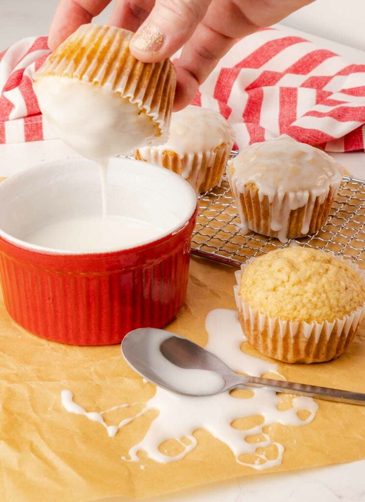 Hand holding Eggnog Muffin dipped into glaze.