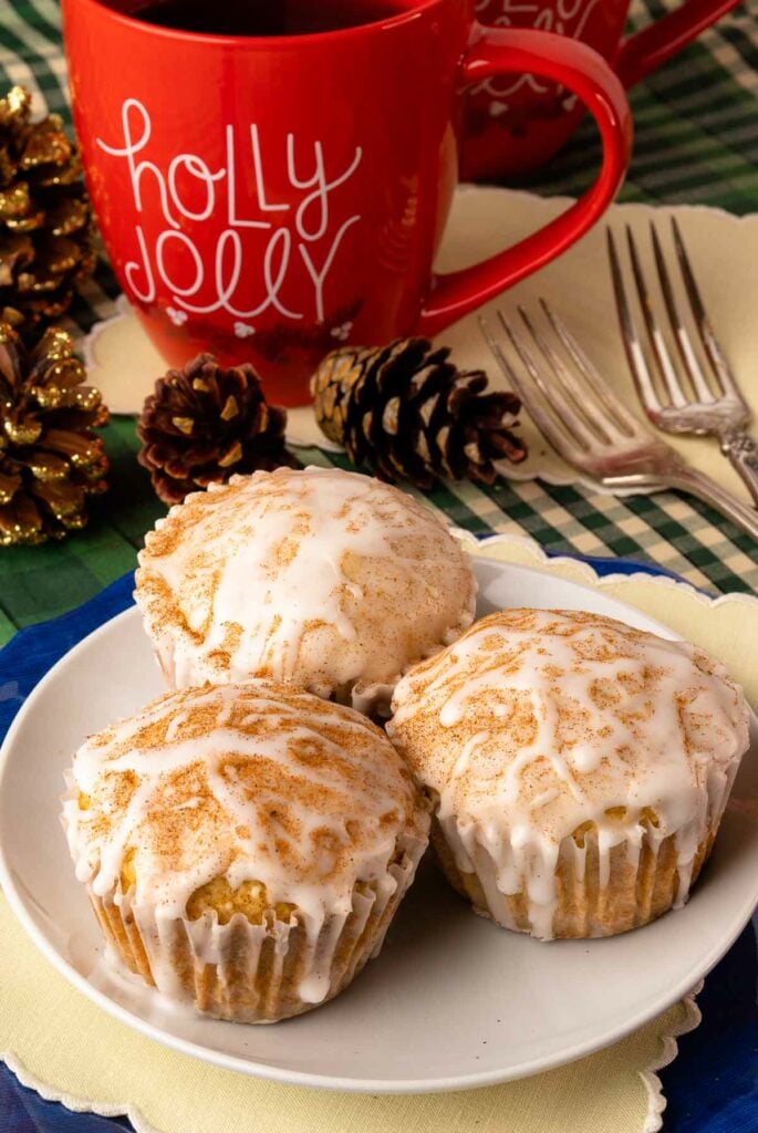 Eggnog Muffins on a white plate glazed with eggnog and sprinkled with cinnamon.