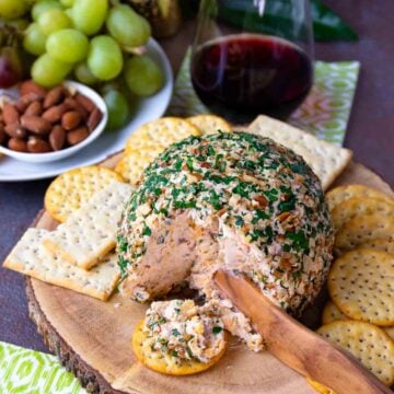 Pineapple Bacon Cheese Ball cut and served on a round cracker for cocktails.