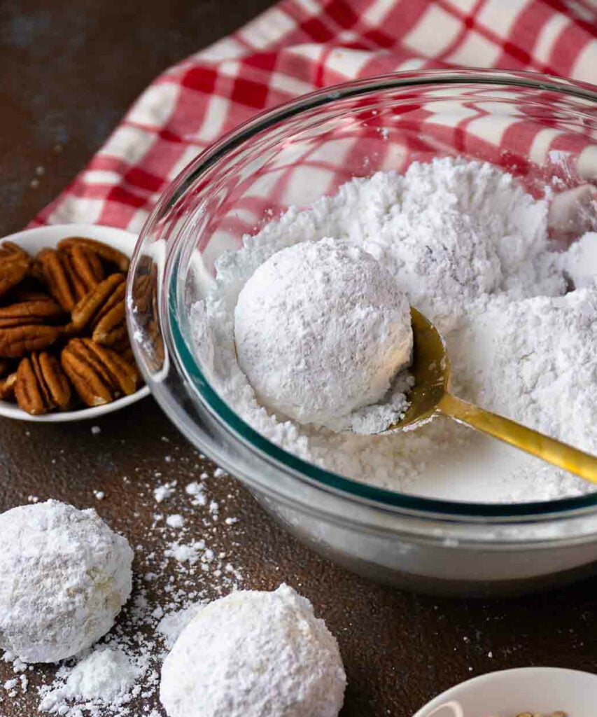 Snowball Cookies dipped in powdered sugar made with chopped pecans.