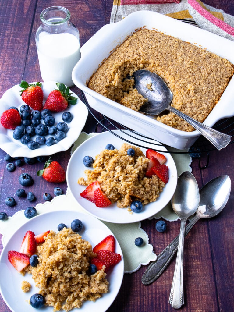 Maple Cinnamon Baked Oatmeal in a pan with fruit and milk.